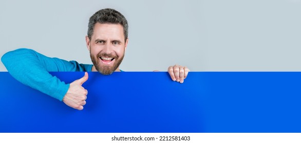 Man Face Portrait, Banner With Copy Space. Product Presenting. Presenting Novelty Information. Male Behind Blue Paper Show Thumb Up.