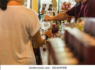 Man In Face Shield Pouring Fresh Juice Into Plastice Glass For Customer In Cafe