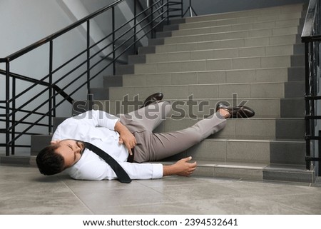 Man fallen down stairs suffering from pain indoors, space for text