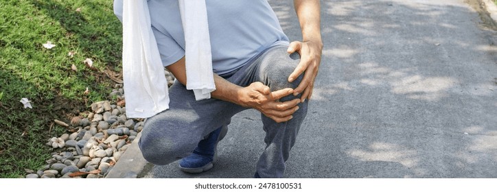 Man falling down and getting knee hurt from walking or jogging exercise at the park. pain and injury for elderly insurance concept.