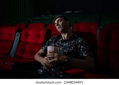 Man falls asleep while watching movie in cinema and popcorn in hand, Movie lacking interesting and boring. - Powered by Shutterstock