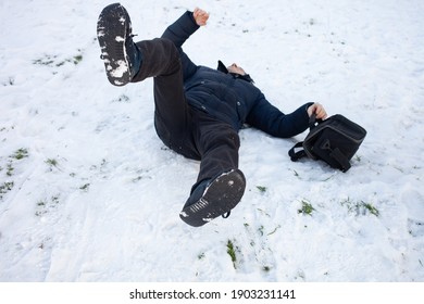 A Man Falls In The Snow. The Man Slipped And Was Injured. Falling On Slippery Ice. Winter. Fracture, Bruise, Dislocation.