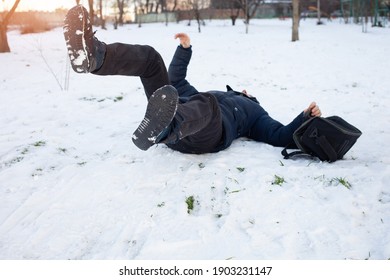 A Man Falls In The Snow. The Man Slipped And Was Injured. Falling On Slippery Ice. Winter. Fracture, Bruise, Dislocation.