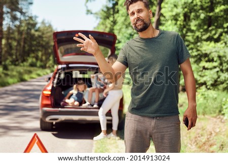 Man with family with broken car on the road