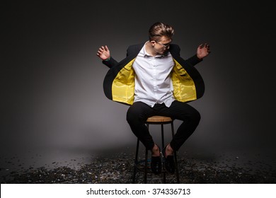 Man in fashion cloth sititng on the chair over black background