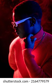 Man Fashion. Neon Light Portrait. Night Life. Attractive Confident Male In Stylish Outfit Trendy Sunglasses Bright Colorful Glow At Dark Studio Background.