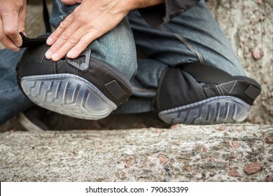 man fastens the knee with a protector for the worker