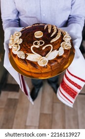 A Man, A Father, Holds A Round Loaf Decorated With Flowers, A Swan With An Embroidered Towel In His Hands. Close-up Wedding Food Photography, Traditions.