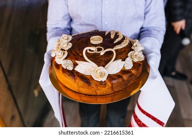 A Man, A Father, Holds A Round Loaf Decorated With Flowers, A Swan With An Embroidered Towel In His Hands. Close-up Wedding Food Photography, Traditions.