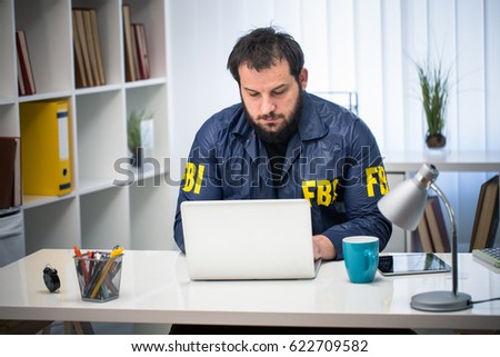 Man FBI agent working in his office on computer alone