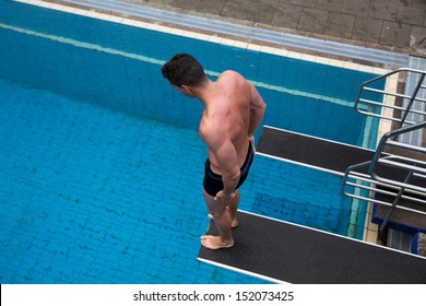 Man With Fear Of Height Standing On Diving Board At Public Swimming Pool Above The Water