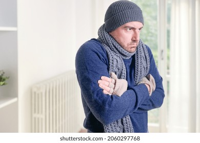 Man Feeling Cold At Home With Home Heating Trouble