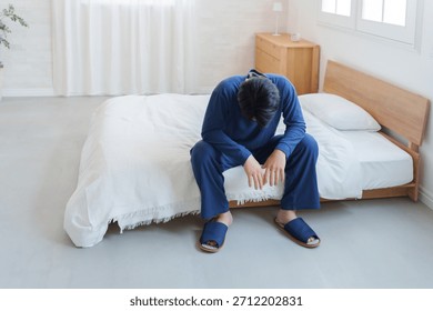 Man feeling depressed while sitting on the bed