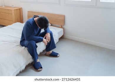 Man feeling depressed while sitting on the bed