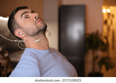Man feeling discomfort while using old fashioned wired earphones 