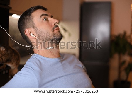 Man feeling discomfort while using old fashioned wired earphones 