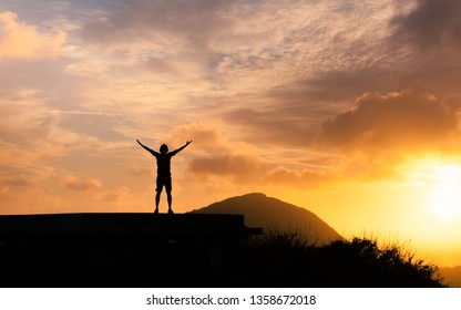 Man feeling happy and free with arms outstretched facing the sunrise.  - Shutterstock ID 1358672018