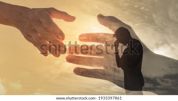 Man feeling sad and\
someone giving him a helping hand. Out of the darkness and into the\
light concept. 