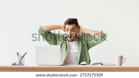 Man Feels Frustrated While Working at Desk With Laptop During Daytime
