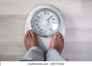 Man Feet On Weight Scale. Obesity And High Cholesterol