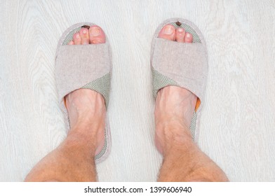 Man Feet Standing At Wooden Floor Ware In Fabric Home Slippers