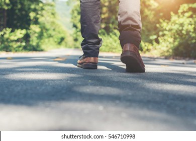 Man Feet Walking On The Rural Road On Vacation. Holiday Tourism Concept.