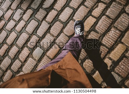 Man feets POV walking on the cobblestone paved roads of Hamburg