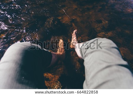 Man feets in river water, man enjoying summer first person perspective