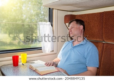 A man fell asleep while reading a book in his compartment car, got seasick on the train.
