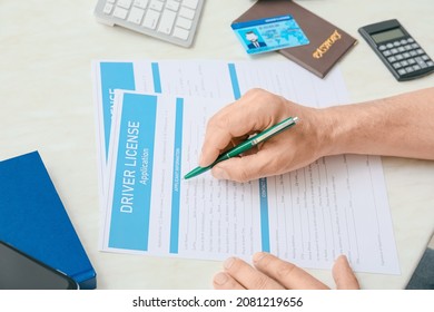 Man Filling In Driving License Application At Table