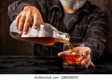 Man Filling A Glass With Whiskey.