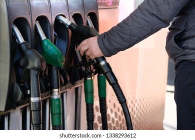 Man fills up his car with a gasoline at gas station. Petrol station pump. To fill car with fuel. Gasoline and oil products.