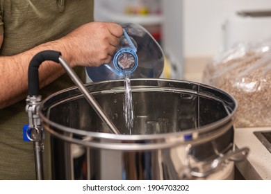 a man fills the kettle with water to make beer
