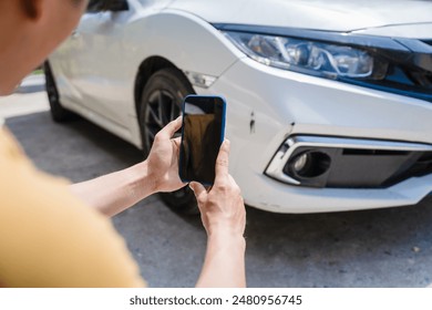Man fills out a car insurance form after a car accident. Comprehensive motor insurance covers car damage. He files a claim report, speaking with an adjuster to understand his coverage and deductible.