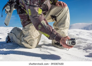 a man filming with action camera in snowy mountain range