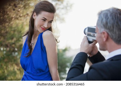 Man Filming Confident Woman With Camera