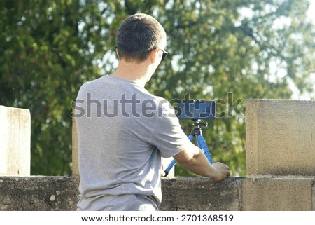 Man filming himself using tripod-mounted phone at Kalemegdan Fortress in Belgrade, Serbia. Symbol of solo content creation, cultural travel vlogging, Balkan tourism, and self-guided storytelling.