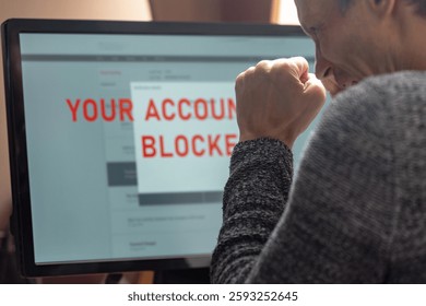 Man with financial problems trying to make online payment. Man frustrated, staring at monitor with account freeze, payment block, and card lock alert