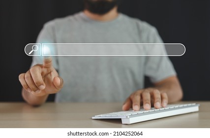 Man finger pointing at searching for information with computer keyboard. Using search website. taskbar start menu type to search bar.