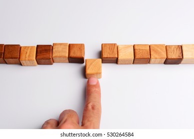 Man finger put last cube wood block to complete and finish wood block in line, symbolizing joining team or making unity teamwork, successful, or completion.    - Powered by Shutterstock