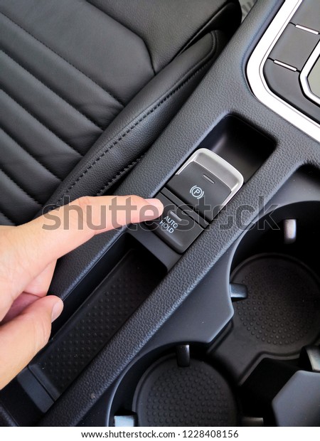 A man fingger push/pull the
Electric electronic Parking Brake with Auto-hold on modern
vehicle