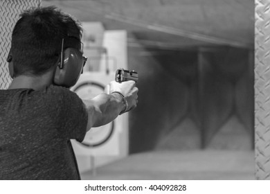 Man Firing Pistol At Target In Indoor Fining Range
