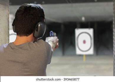 Man Firing Usp Pistol At Target In Indoor Shooting Range