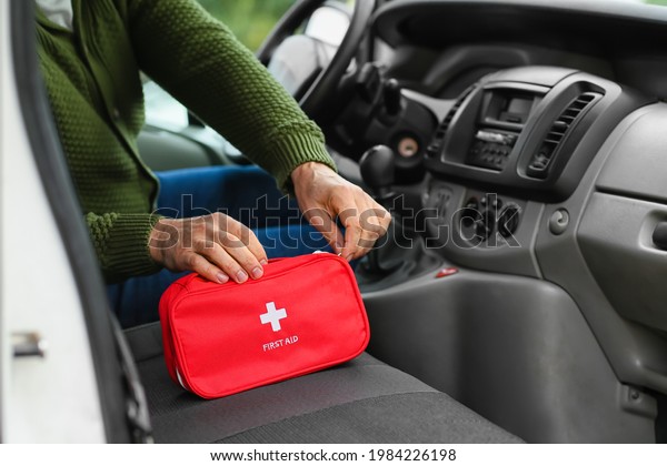 Man with first aid kit in\
car