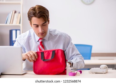 Man With First Aid Kit In The Office