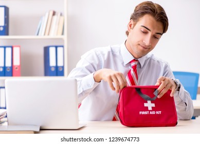 Man With First Aid Kit In The Office