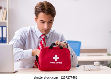 Man With First Aid Kit In The Office