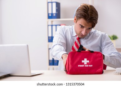 Man With First Aid Kit In The Office