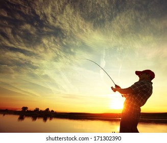 Man Fishing From A Boat At Sunset