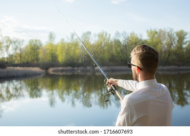 A Man Fishing In A Business Suit, In A White Shirt And Tie